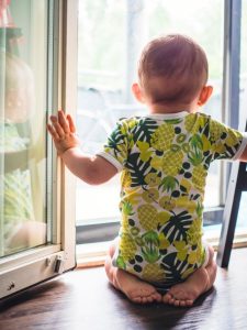 vauva katselee polvillaan keittiötason päältä ikkunasta